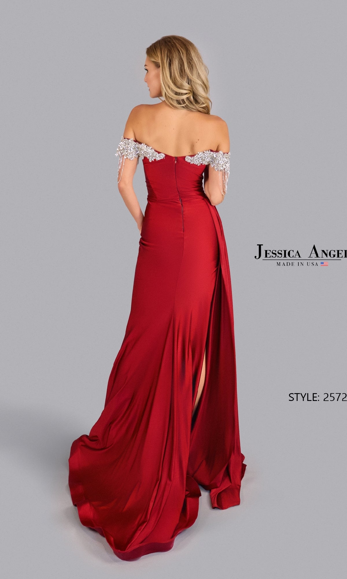 A woman stands with her back to the camera in an Off-Shoulder Jersey Prom Dress: Jessica Angel 2572, featuring embellishments, against a plain background.